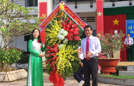 Đồng chí Thái Bảo, Trưởng ban Tuyên giáo Tỉnh uỷ tặng hoa chúc mừng thầy cô giáo và học sinh Trường THPT Nguyễn Bỉnh Khiêm nhân ngày khai giảng năm học mới (Ảnh: Nga Sơn)