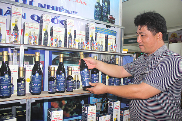 Ông Phạm Văn Sơn giới thiệu quầy bán sản phẩm dâu tằm men tự nhiên tại Hội chợ Hàng Việt Nam chất lượng cao năm 2018. 