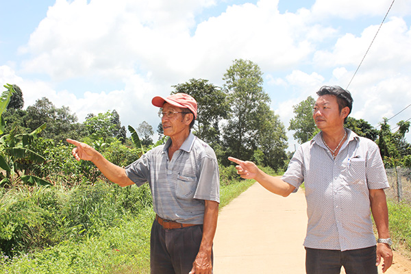 Ông Đoàn Thanh Quang (trái), Trưởng ấp 2A, xã Xuân Bắc (huyện Xuân Lộc) và lão nông Nguyễn Văn Thuận thăm vườn xoài được thay giống mới năng suất hơn.