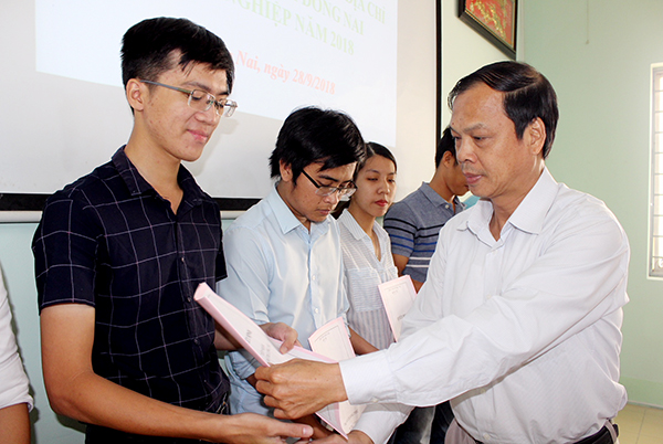 Bác sĩ Hà Đức Minh, Trưởng phòng Tổ chức cán bộ Sở Y tế trao quyết định phân công công tác cho các tân bác sĩ, dược sĩ năm 2018.