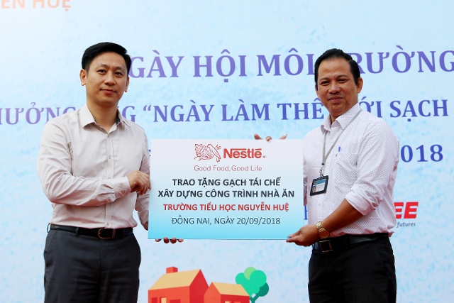 Đại diện Công ty Nestlé Việt Nam trao tượng trưng 10 ngàn viên gạch cho Trường tiểu học Nguyễn Huệ 