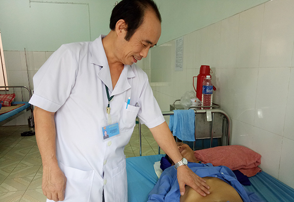 Bác sĩ Đinh Sỹ Hòa thăm khám cho bệnh nhân N.V.P. Ảnh: H.DUNG