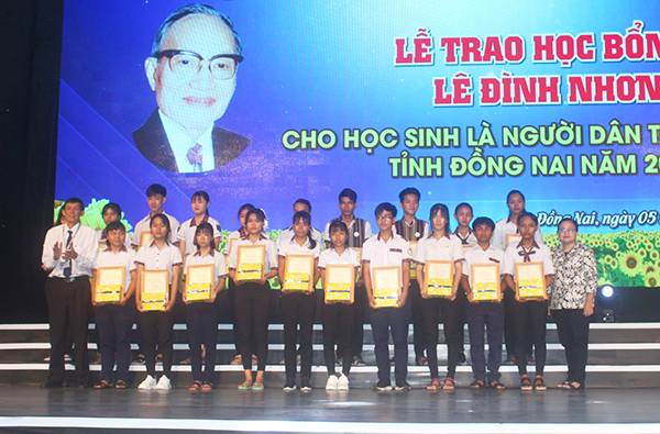 Ông Trần Nam Đông, Giám đốc Đài PT-TH Đồng Nai và đại diện gia đình đồng chí Lê Đình Nhơn trao học bổng cho các em học sinh.