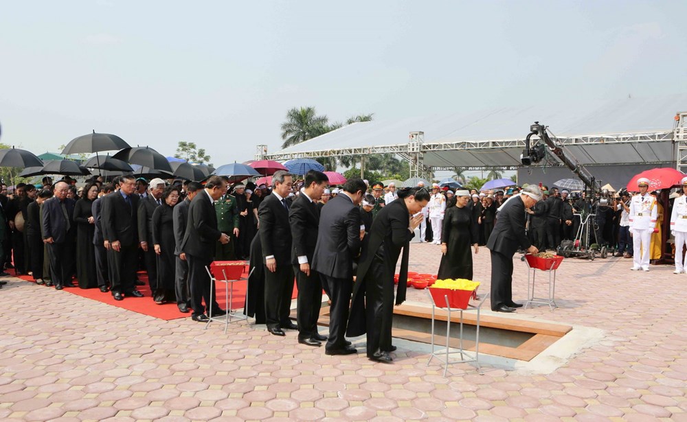 Các đồng chí lãnh đạo, nguyên lãnh đạo Đảng, Nhà nước, Mặt trận Tổ quốc Việt Nam thả những nắm đất đầu tiên xuống huyệt mộ nguyên Tổng Bí thư Đỗ Mười. (Ảnh: Dương Giang/TTXVN)