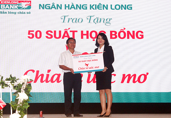 Đại diện lãnh đạo ngân hàng Kiên Long (phải) trao 50 suất học bổng cho học sinh trong huyện thông qua lãnh đạo Ủy ban MTTQ Việt Nam huyện Long Thành.