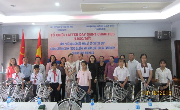 Các đại biểu chụp hình lưu niệm với các em học sinh được tặng xe đạp (Ảnh: Hội Nạn nhân chất độc da cam/dioxin tỉnh cung cấp)