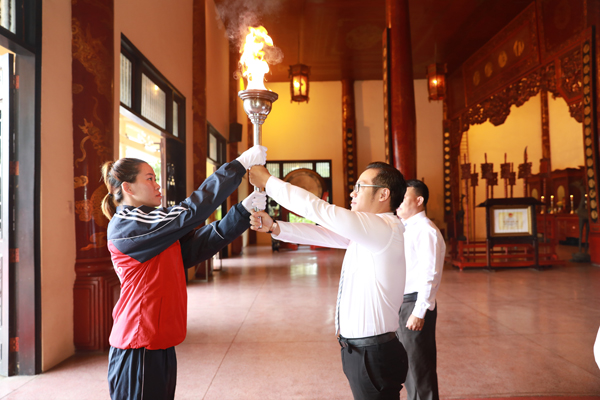 Ông Nguyễn Xuân Thanh, Phó giám đốc Sở Văn hóa, thể thao – du lịch trao ngọn đuốc cho VĐV tiêu biểu Nguyễn Thị Thu Hạnh để thực hiện nghi thức rước đuốc