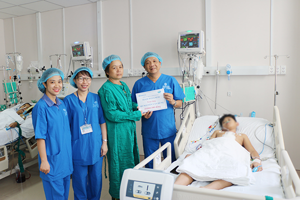 Giám đốc Bệnh viện đa khoa Đồng Nai Ngô Đức Tuấn (bìa phải) trao tặng số tiền 25 triệu đồng vận động hỗ trợ mổ tim cho gia đình bệnh nhân N.V.K.