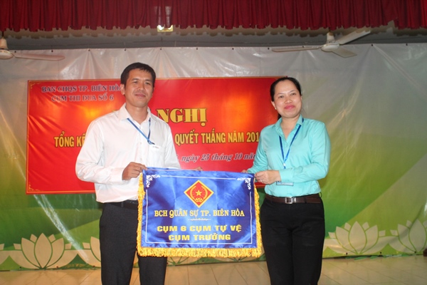 Bà Ngô Thị Hoàng Oanh, giám đốc Nhà thiếu nhi tỉnh trao cờ cụm trưởng Cụm thi đua số 6 năm 2019 cho đại diện đơn vị Điện lực Biên Hòa 