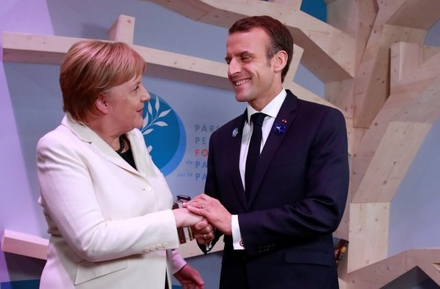 Thủ tướng Đức Angela Merkel (trái) và Tổng thống Pháp Emmanuel Macron tại Diễn đàn Hòa bình Paris. (Nguồn: US News & World Report)