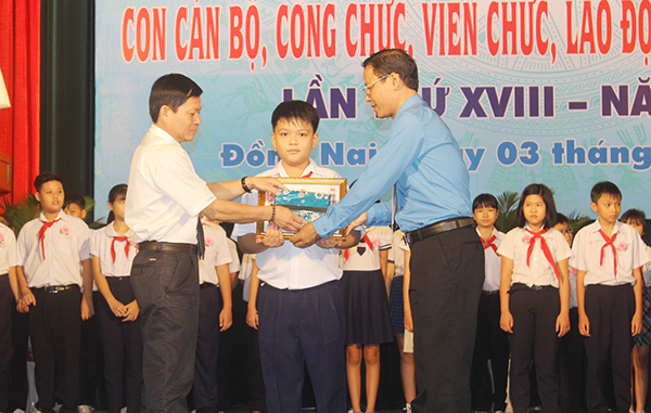 Chủ tịch Công đoàn viên chức tỉnh Phạm Văn Chiến (bên phải) khen thưởng con của đoàn viên, người lao động trong khối Công đoàn viên chức đạt thành tích học giỏi - sống tốt năm 2018.