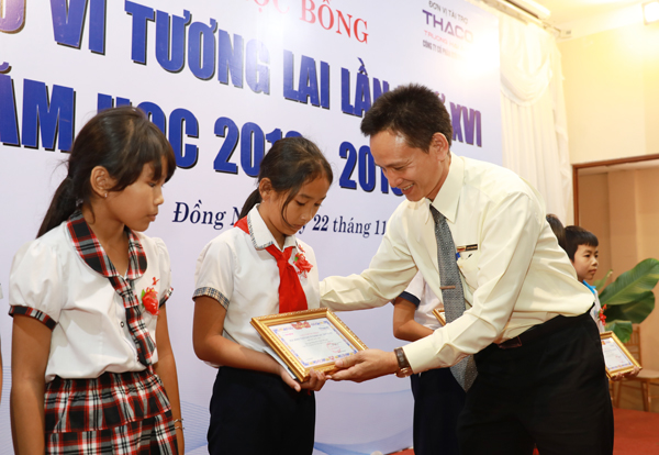 Ông Đoàn Công Thành, Phó giám đốc chi nhánh tải, buýt Đồng Nai, Đại diện Công ty cổ phần oto Trường Hải trao học bổng cho các em học sinh.