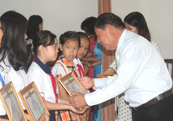 Ông Huỳnh Cao Hải, Phó giám đốc Sở Y tế trao thưởng cho nữ học sinh trong gia đình tiêu biểu sinh con một bề là gái học giỏi, sống tốt 