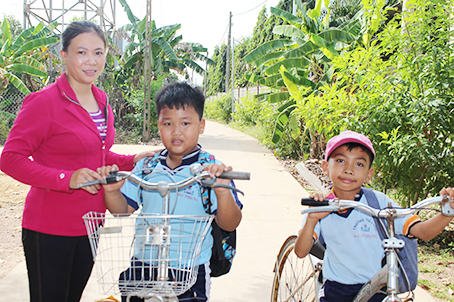 Chị Ninh Thị Gái và các em học sinh Trường tiểu học Bàu Phụng trên tuyến đường sáng- xanh- sạch - đẹp ở ấp Bàu Phụng, xã Mã Đà (huyện Vĩnh Cửu) được xây dựng vào đầu năm 2018.