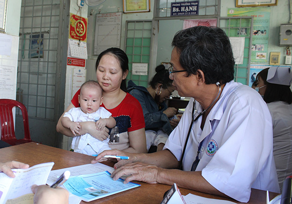 Bác sĩ khám, tư vấn và hướng dẫn phụ huynh theo dõi trẻ trước khi tiêm Vaccine ComBE Five tại Trạm y tế phường Trảng Dài.