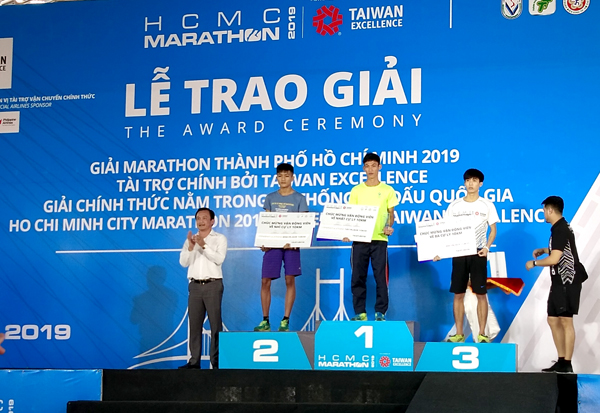 Hai VĐV Đồng Nai Lê Hữu Lộc và Lương Đức Phước trên bục nhận giải Nhất và giải Nhì cự ly marathon nữ (42km) hệ chuyên nghiệp.