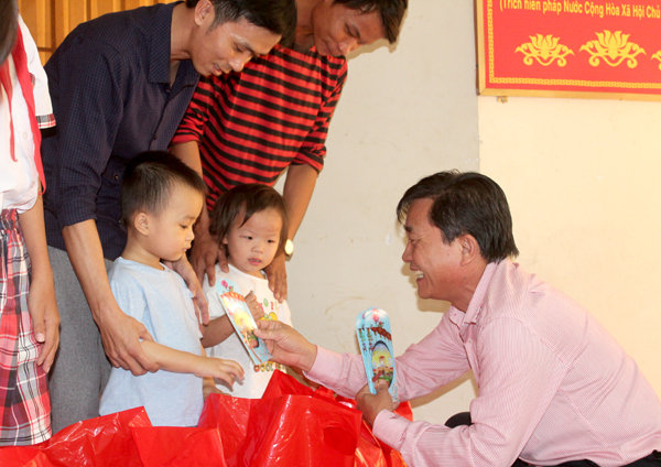 Ông Hoàng Văn Long, Giám đốc Quỹ Bảo trợ trẻ em tỉnh Đồng Nai trao quà cho thiếu nhi ở xã Vĩnh Thanh, huyện Nhơn Trạch. Ảnh: N.Sơn