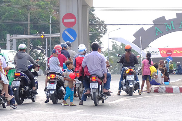 Trẻ ăn xin len lỏi vào luồng giao thông để xin tiền từ người tham gia giao thông tại ngã tư Amata.