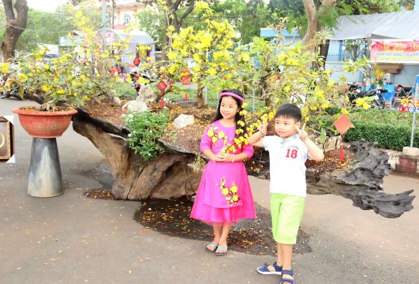 trẻ em chụp ảnh tại tiểu cảnh bonsai ở đường hoa xuân Kỷ Hợi 2019, TX. Long Khánh. (ảnh: Văn Truyên).