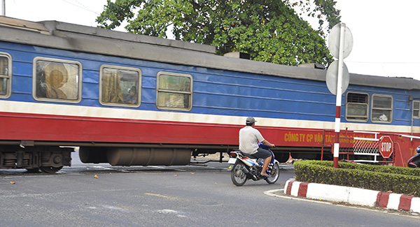 Một người đàn ông điều khiển xe máy vượt rào chắn dù tàu hỏa đang chạy (đoạn giao giữa đường sắt với đường Đồng Khởi, thuộc phường Tân Hiệp, TP.Biên Hòa) đi vào đường ray (Ảnh chụp ngày 14-2-2019)