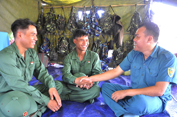 Đại diện Ban Chỉ huy quân sự xã Phước Bình (huyện Long Thành) đến động viên, thăm hỏi 2 tân binh Dương Văn Hiếu (bìa trái) và Dương Văn Đạt (giữa) trước giờ lên đường nhập ngũ. Ảnh: Thanh Hải
