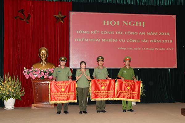 Đại diện Phòng Cảnh sát kinh tế Công an tỉnh (bìa phải) nhận cờ thi đua xuất sắc  trong phong trào thi đua vì an ninh Tổ quốc cấp cơ sở năm 2018 của Bộ Công an