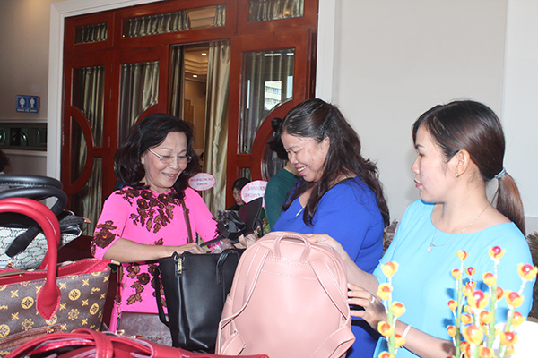 Bà Lê Thị Thu Trang (bìa trái), chủ Cơ sở may ba lô, túi xách Minh Trang (huyện Long Thành) giới thiệu sản phẩm tại Ngày hội Phụ nữ sáng tạo, khởi nghiệp năm 2018. Ảnh: N.Sơn