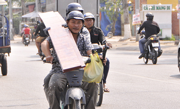 Vận chuyển những tấm ván gỗ dài ngoằng gây khó khăn cho 2 người đi xe máy chạy trên đường Võ Thị Sáu, đoạn qua phường Thống Nhất (TP.Biên Hòa)
