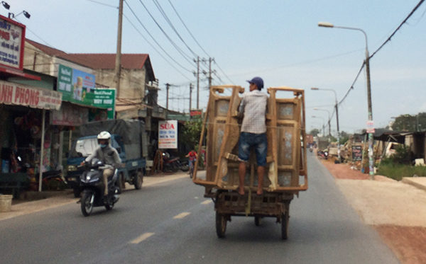 Một xe máy kéo theo xe hàng chằng buộc không cẩn thận rất nguy hiểm lưu thông trên đường Điểu Xiển, đoạn qua xã Hố Nai 3 (huyện Trảng Bom)