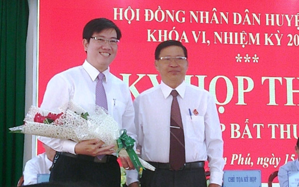 Bí thư Huyện ủy Tân Phú - Trần Bá Đạt (bên phải) tặng hoa chúc mừng Phó chủ tịch UBND huyện Bùi Thanh Nam