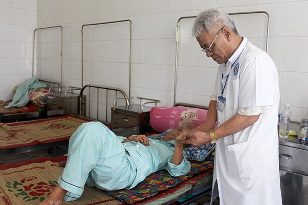 Bác sĩ Nguyễn Văn Ba, Trưởng khoa Điều trị phong Bệnh viện da liễu Đồng Nai khám bệnh cho bệnh nhân phong 