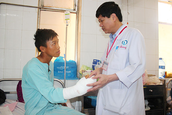  Bác sĩ CKII Nguyễn Tường Quang hướng dẫn bệnh nhân cử động bàn tay sau khi được nối mạch máu.
