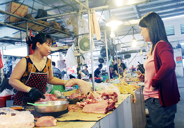 Người tiêu dùng chọn mua thịt heo tại một sạp thịt ở chợ Tân Hiệp (TP.Biên Hòa)