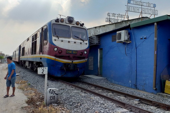 Xe lửa dừng lại gần trạm gác đường sắt chờ nhân viên Điện lực Biên Hòa và VNPT Đồng Nai tháo dây điện, viễn thông võng xuống ngang đường ray