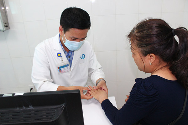 Bác sĩ CKI da liễu Nguyễn Quốc Viễn thăm khám cho một bệnh nhân bị bệnh lý về da trong mùa nắng nóng
