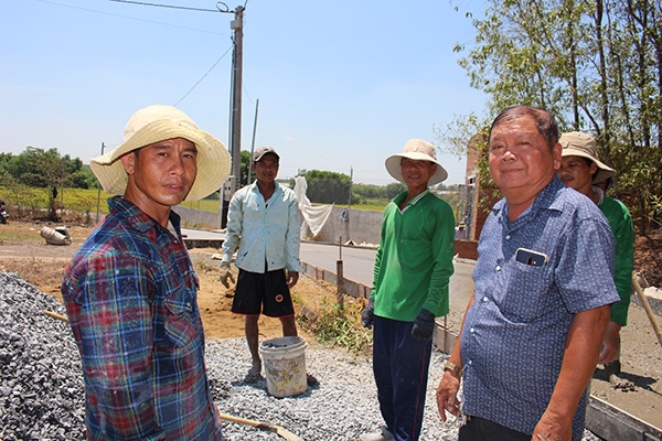 Ông Phan Văn Bảy (bìa phải), Bí thư Chi bộ ấp Vàm, xã Thiện Tân (huyện Vĩnh Cửu) kiểm tra công tác thi công đường nông thôn ở tổ 7 .Ảnh: Đ.Phú