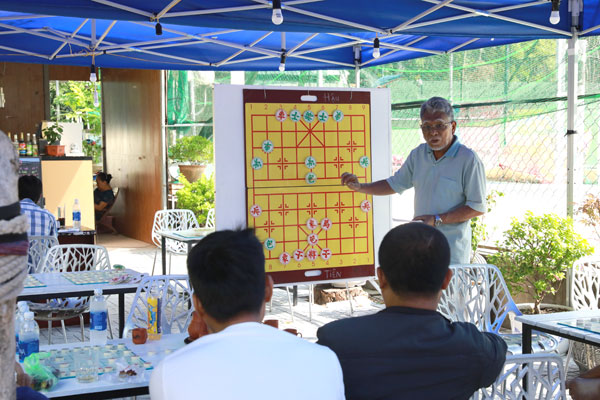 Ông Trương Thanh Bình bình giải cho mọi người quá trình thi đấu của hai kỳ thủ thông qua một bàn cờ lớn.