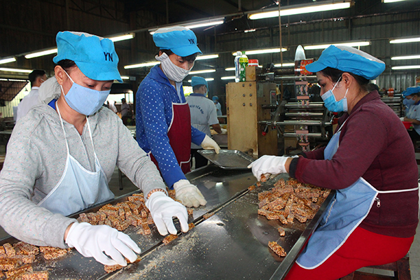 Công nhân lao động một cơ sở sản xuất bánh kẹo trên địa bàn phường Thống Nhất (TP.Biên Hòa) tuân thủ quy định về an toàn vệ sinh thực phẩm trong quá trình sản xuất bánh kẹo. Ảnh: H.DUNG 