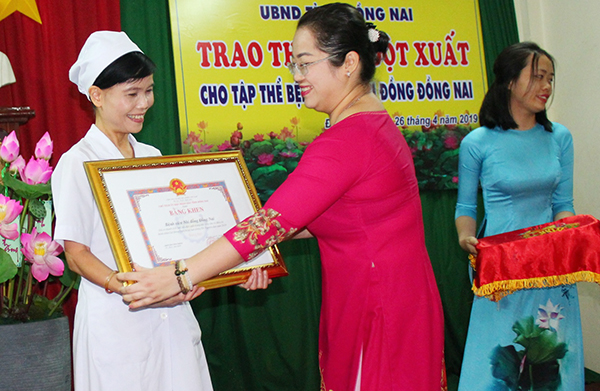 Trưởng Ban Thi đua khen thưởng tỉnh Vy Vũ Hồng Thảo tặng bằng khen của UBND tỉnh cho tập thể Bệnh viện nhi đồng Đồng Nai