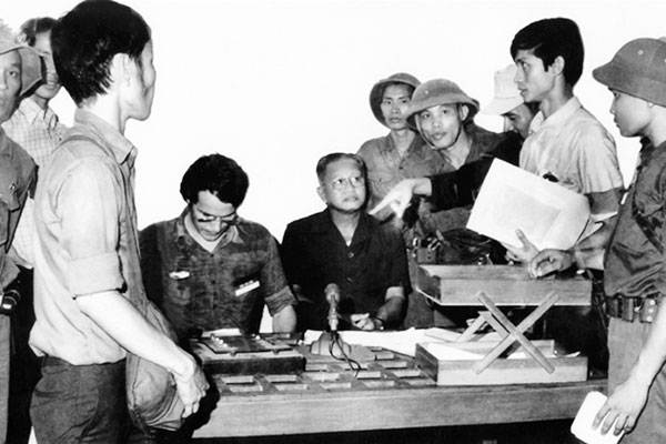 Bức ảnh chụp thời khắc lịch sử Tổng thống chính quyền Sài Gòn Dương Văn Minh (ngồi ngay micro) đọc lời tuyên bố đầu hàng có mặt ông Trịnh Ngọc Ước (đứng thứ 3 từ phải qua)  Ảnh: Tư liệu