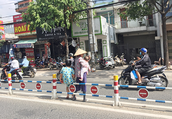 Bất chấp nguy hiểm, 3 bà cháu vẫn “vô tư” đi qua dải phân cách trên đường Nguyễn Ái Quốc, đoạn qua phường Hố Nai