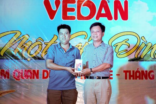 Chủ tịch Công đoàn cơ sở Công ty cổ phần hữu hạn Vedan Việt Nam Phạm Trung Thuyên (phải) tặng quà là một chiếc smartphone cho công nhân lao động bốc thăm trúng thưởng