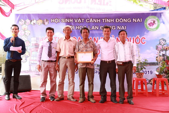 Ban tổ chức trao giải Đặc biệt cho chủ nhân giò lan Hoàng Thảo Ý Ngọc của vườn lan Nam Tuấn đến từ Hội Hoa lan TP.Đà Lạt (ảnh Huy Anh)
