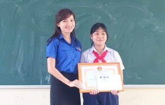 Chị Hồ Hồng Nguyên trao giấy khen và tiền thưởng cho em Vũ Thị Huyền Trang (Hình Q.Trung)