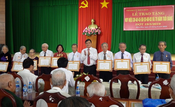 Đồng chí Huỳnh Tấn Đạt-Phó bí thư thường trực Thành ủy Biên Hòa trao huy hiệu Đảng cho các đảng viên 