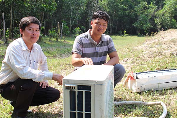 Ông Nguyễn Minh Sang (phải), Tổ phó Tổ tự quản 1 (Tổ tự quản khu Bàu Sen) giữ tang vật là máy điều hòa nhiệt độ mà tên trộm bỏ lại chờ Công an xã tới làm việc 