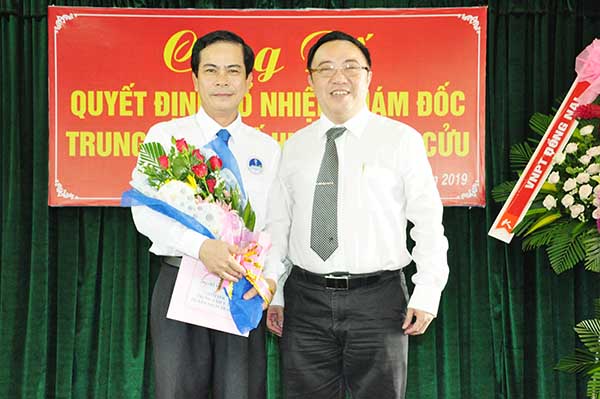 Giám đốc Sở Y tế Phan Huy Anh Vũ (phải) trao quyết định bổ nhiệm chức danh giám đốc Trung tâm y tế huyện Vĩnh Cửu cho bác sĩ Hồ Văn Hoài.
