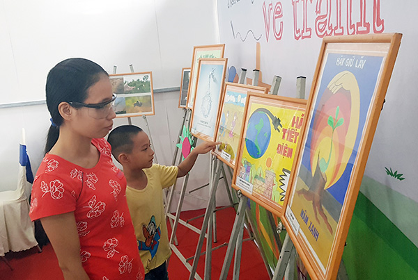 Người dân đến tham quan gian trưng bày các tác phẩm tranh vẽ cổ động vì môi trường tại Ngày hội tái chế chất thải năm 2019.