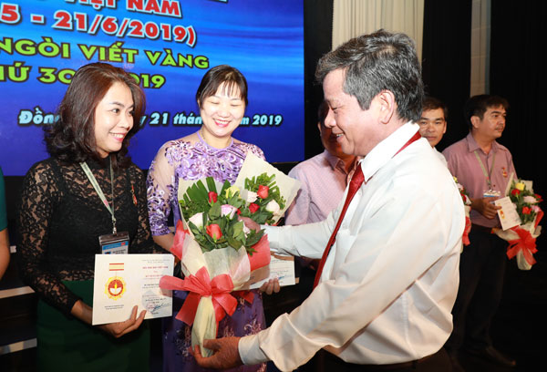 Chủ tịch Hội Nhà báo tỉnh, Tổng biên tập báo Đồng Nai Nguyễn Tôn Hoàn tặng hoa cho các nhà báo được nhận Kỷ niệm chương vì sự nghiệp báo chí