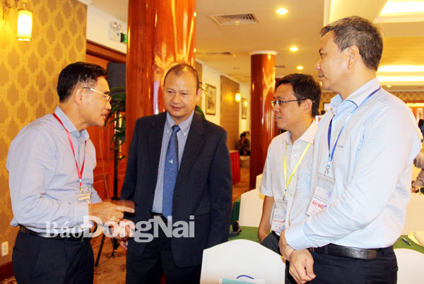 Phó chủ tịch UBND tỉnh Trần Văn Vĩnh (bìa trái) trao đổi với chuyên gia về kết nối giao thông bên lề buổi hội thảo